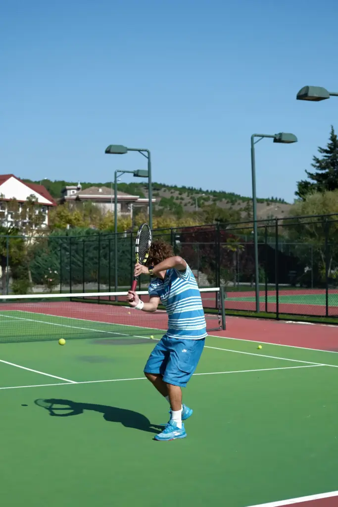 Boy on tennis court serving